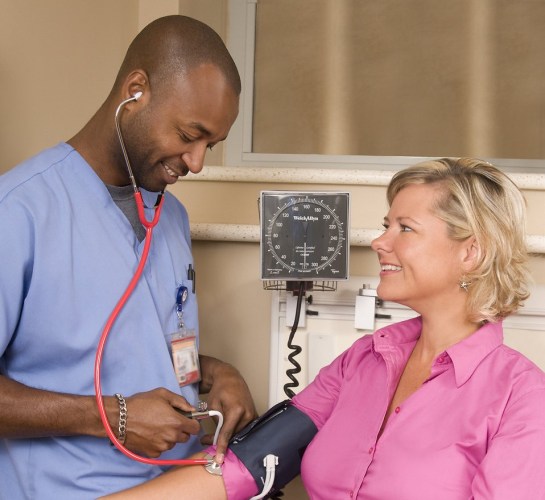 male-nurse-taking-a-womans-blood-pressure-pv